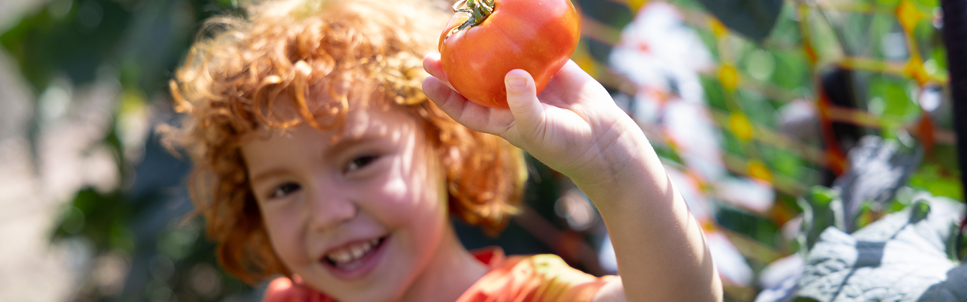 Kind mit Tomate